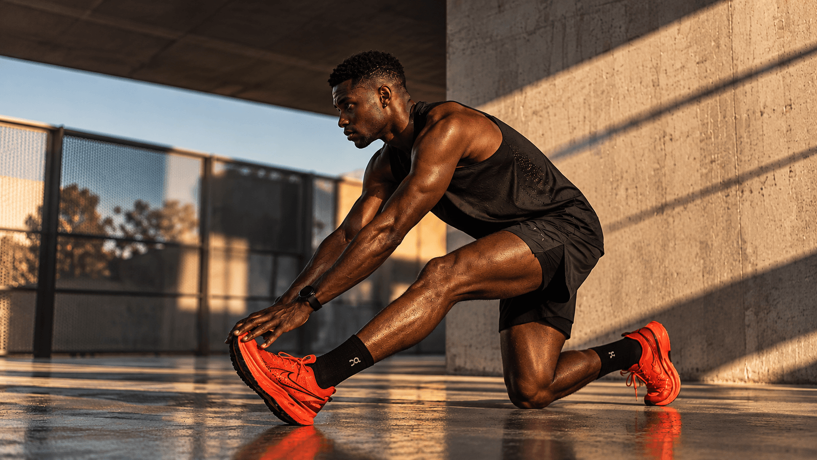 Atleta alongando ao tardecer em um espaço urbano